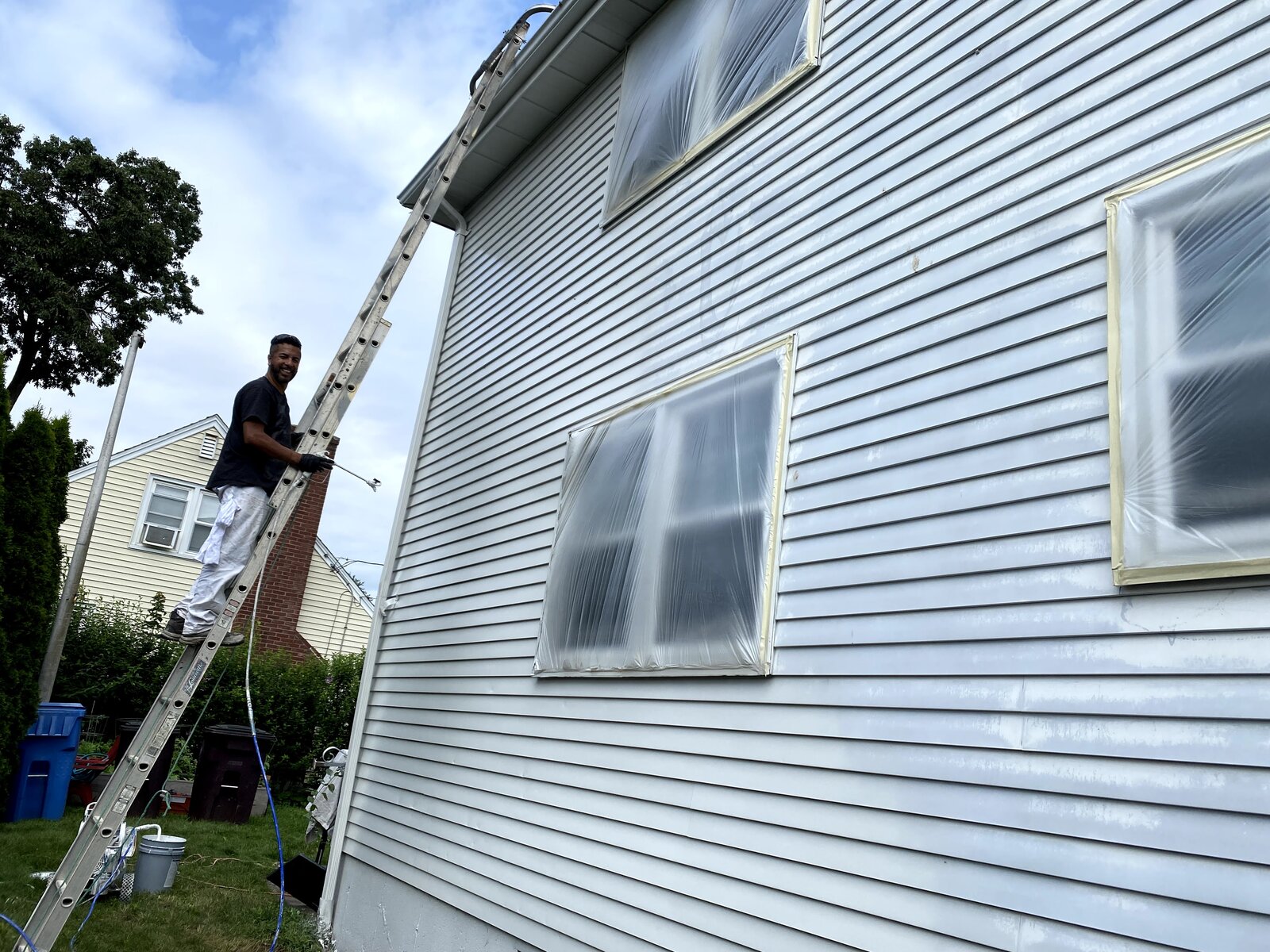 Windows masked, spraying siding